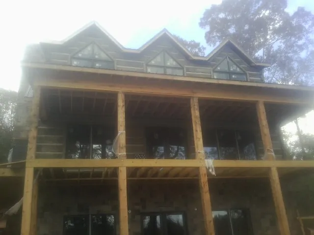 Dormers and porch framing on a large log home under construction — Roof Coating work by our crew in Kenansville